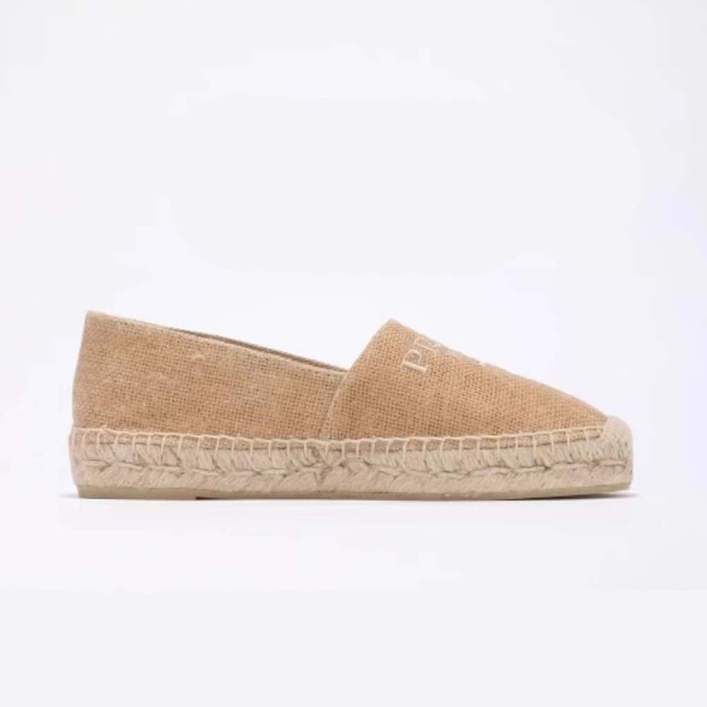 Close-up detail of embroidered logo on beige crochet espadrille