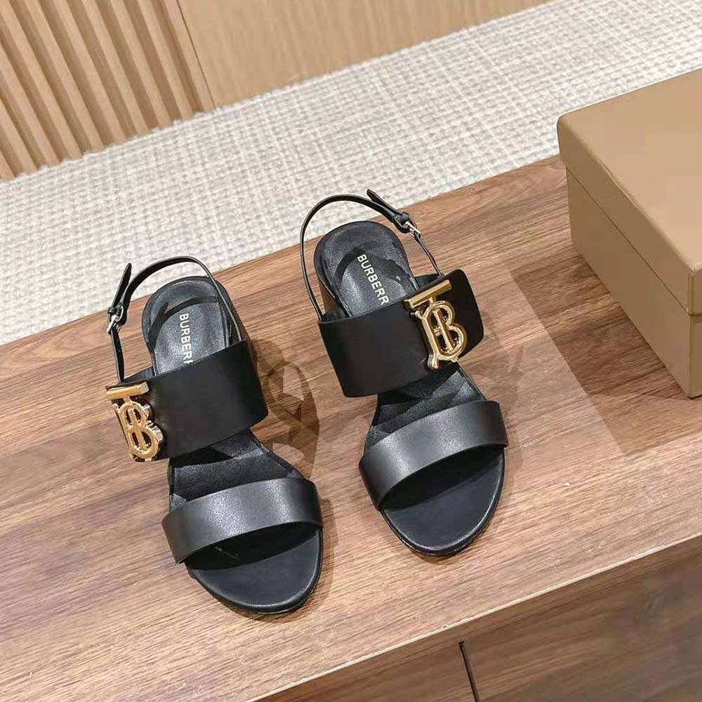 Close-up detail of black leather and monogram motif on Burberry sandals