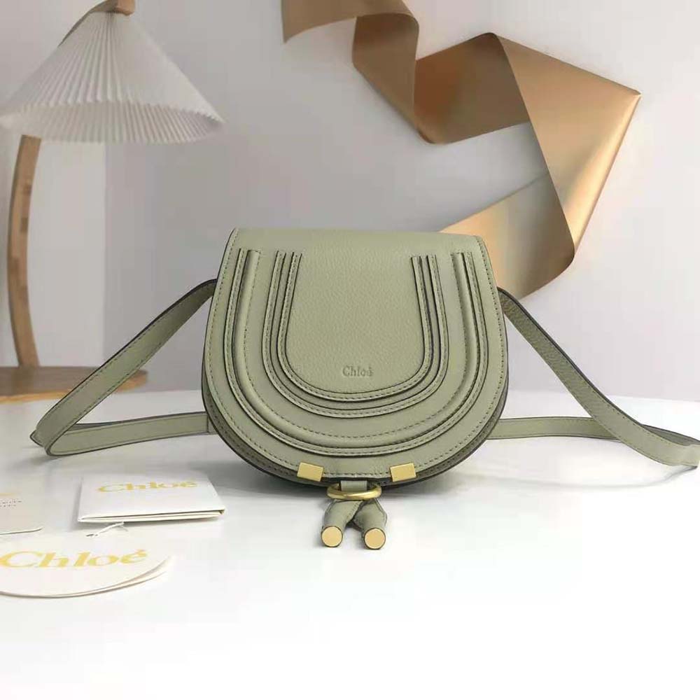 Close-up of gold-tone hardware and flap closure on Chloe Women Marcie Small Saddle Bag-Green