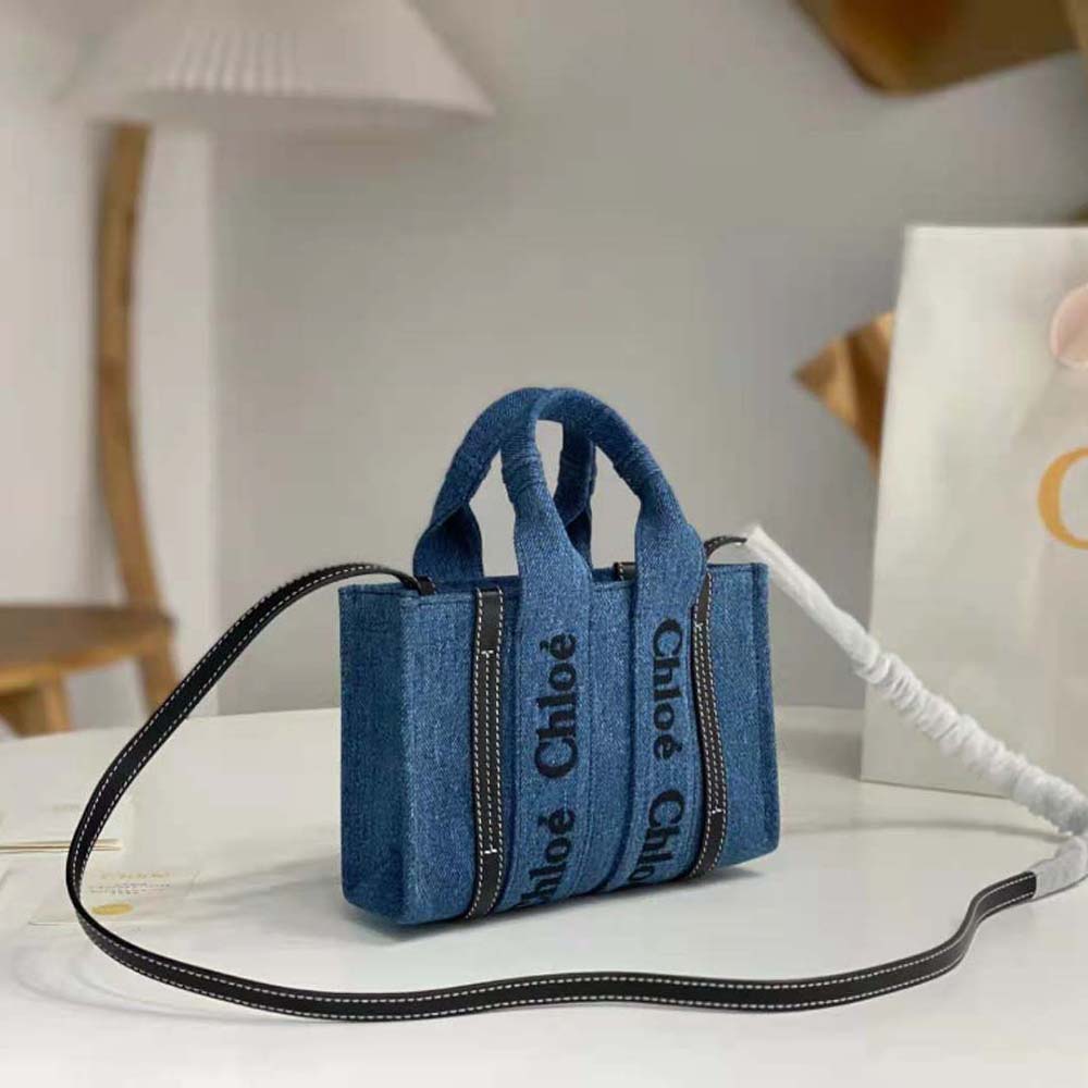 Side view of Chloe Women Small Woody Tote Bag-Navy highlighting suede trim