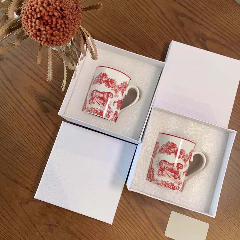 Close-up on embossed Dior emblem on red Toile De Jouy mug