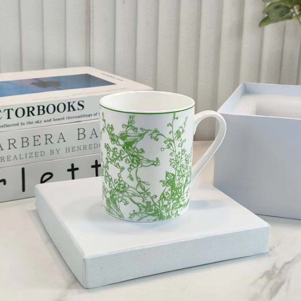 Side angle showing handle and green ceramic finish of Dior Unisex Mug Green New Lily of the Valley