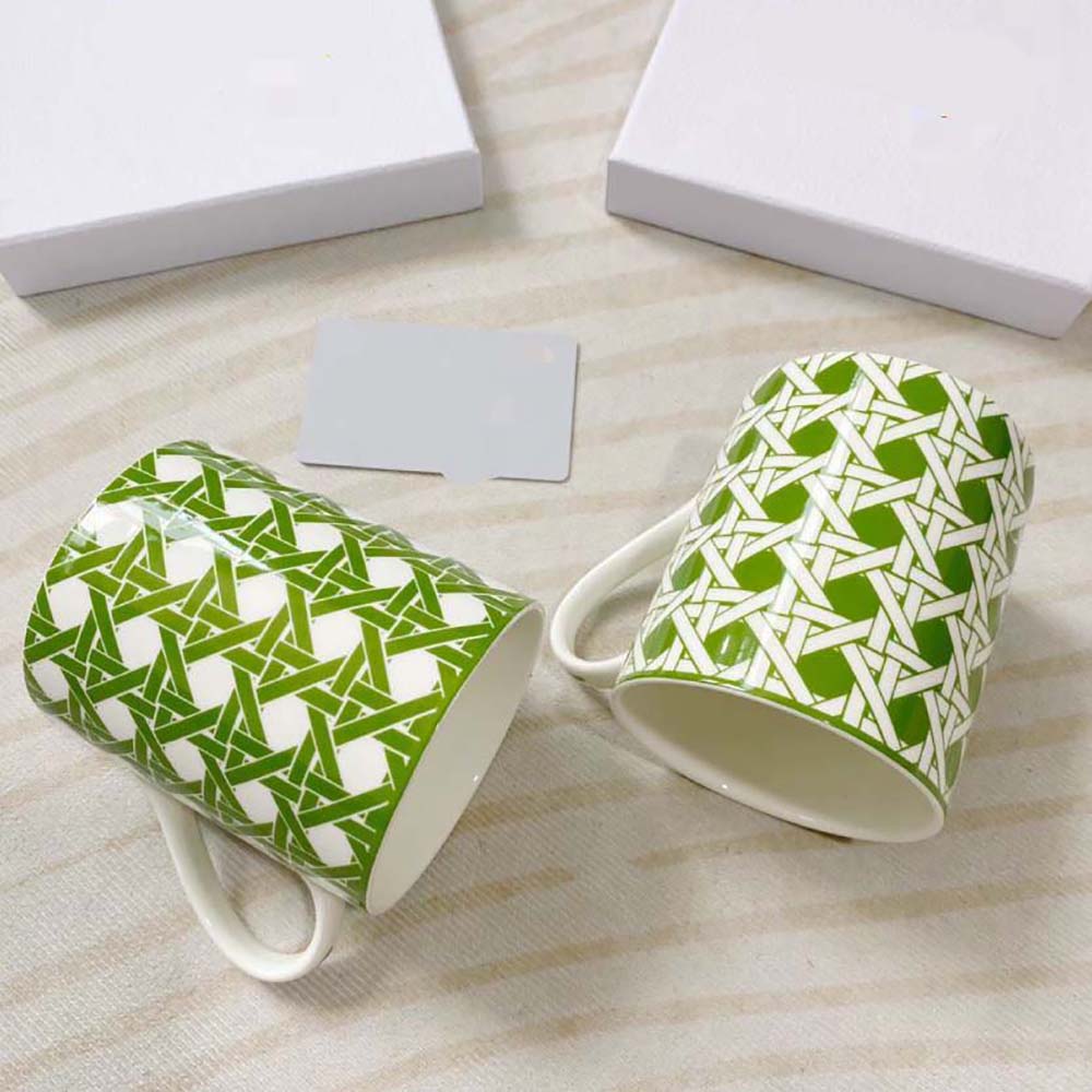 Side view highlighting embossed Dior logo on green Cannage mugs