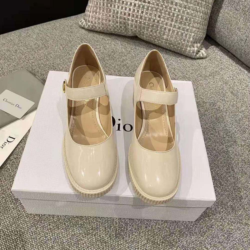 Close-up of Dior D-shaped buckle on white shiny calfskin pump