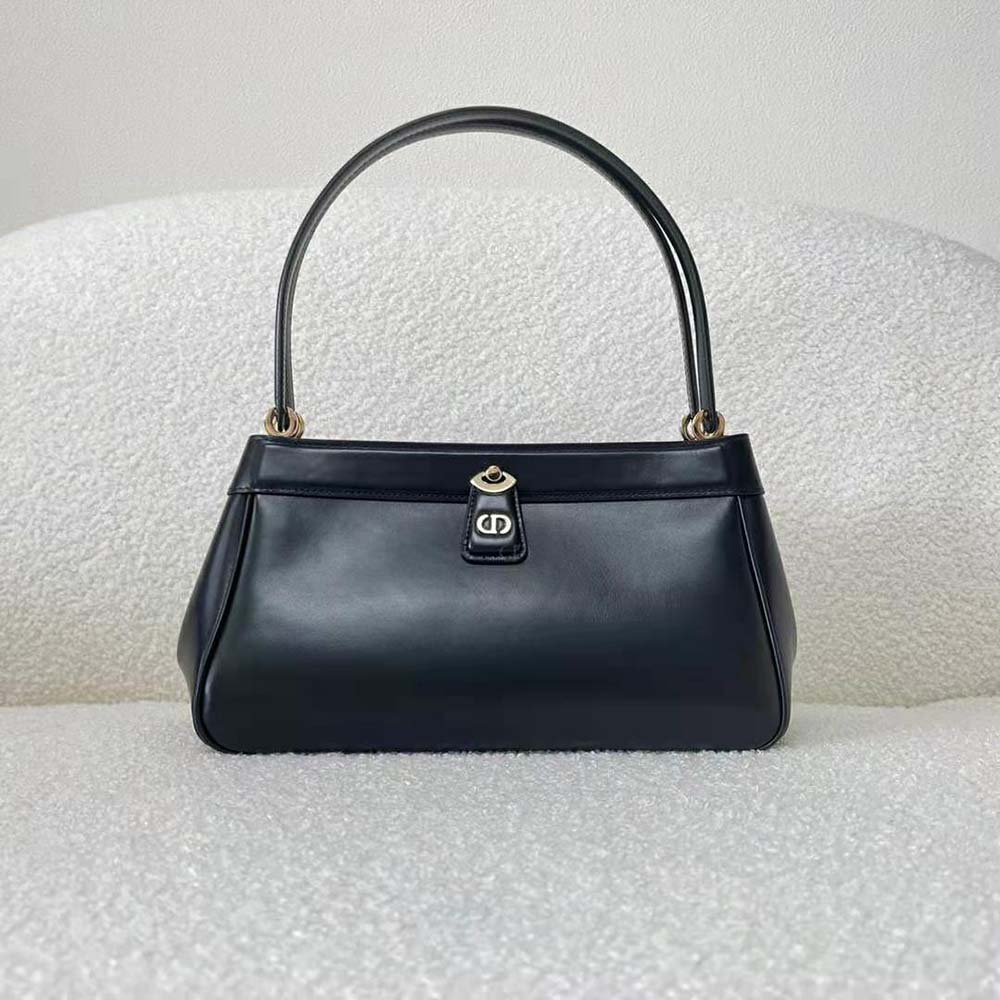 Close-up of gold ‘Dior’ charm on Medium Dior Key Bag black leather
