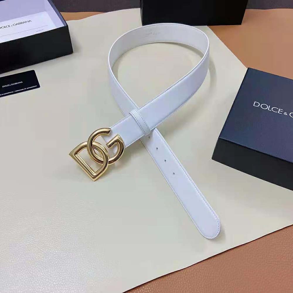 Close-up of silver DG logo buckle on white calfskin belt