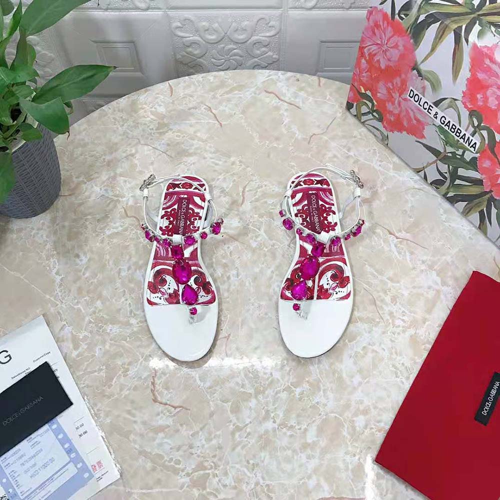 Close-up on glossy patent leather and D&G logo detail on sandals