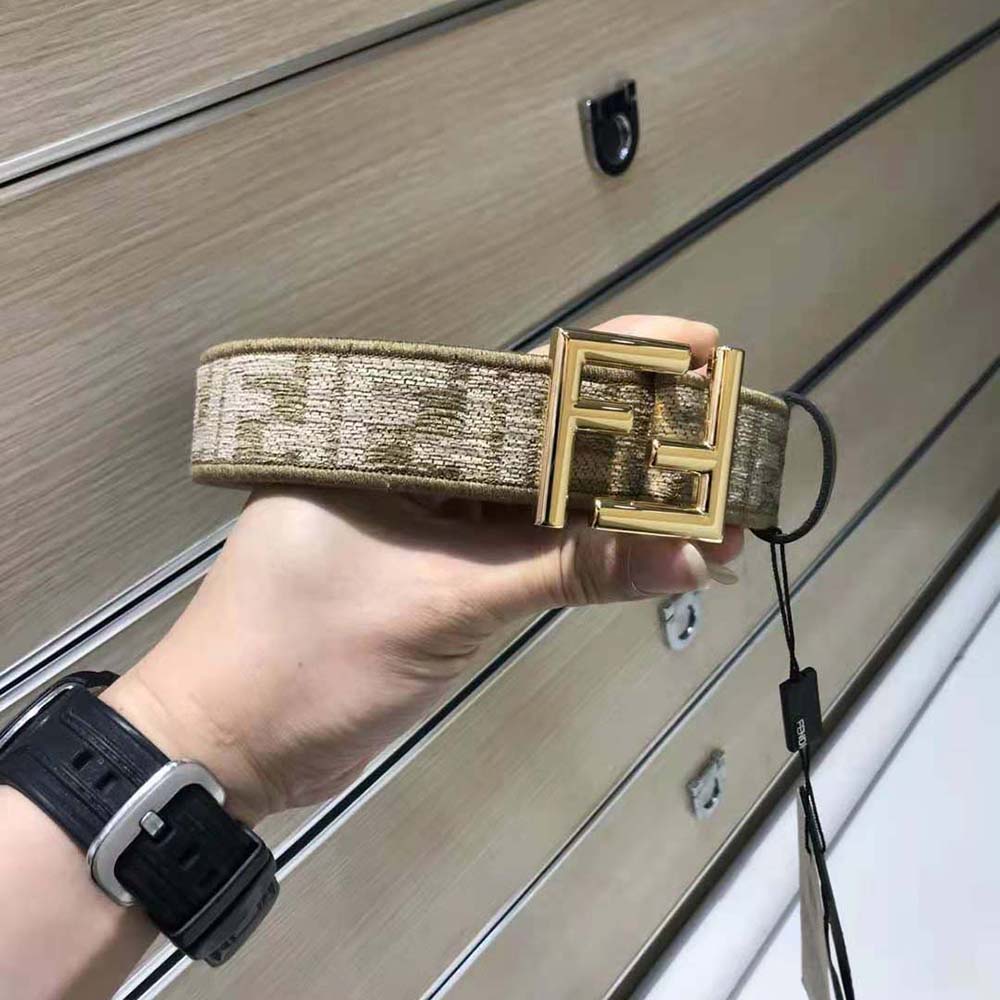 Close-up of polished Fendi hardware on brown fabric belt