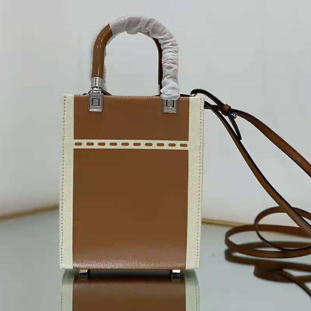Side angle showing brown canvas and sleek silhouette of Fendi Mini Sunshine Shopper