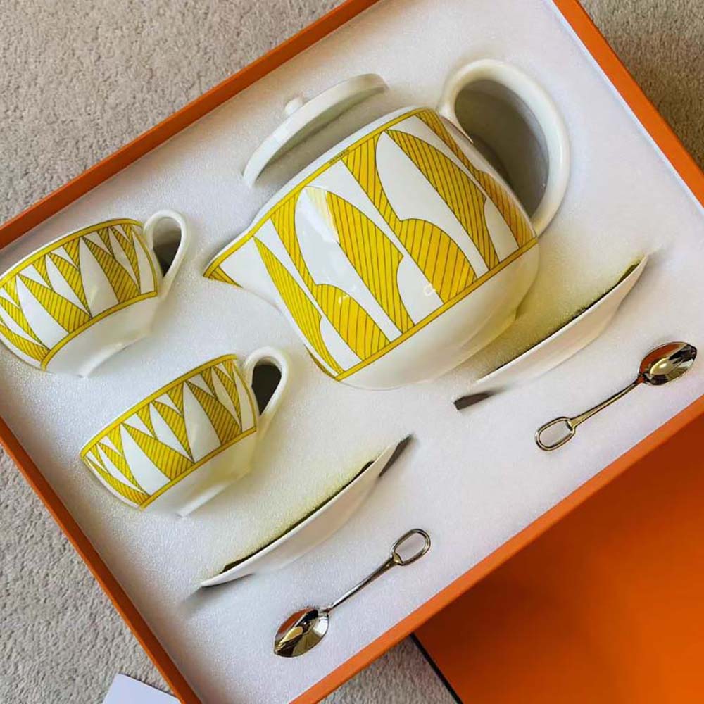 Close-up of gold-tone handle and sun motif lid on Hermes Soleil D’Hermes Teapot