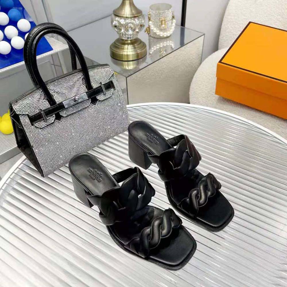 Close-up of signature Hermes 'H' hardware on black sandal