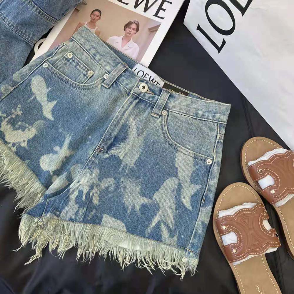 Close-up of Loewe stitched logo detail on blue denim shorts