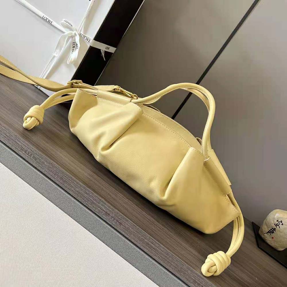 Side angle showing silhouette and strap of Loewe Small Paseo Bag Gold