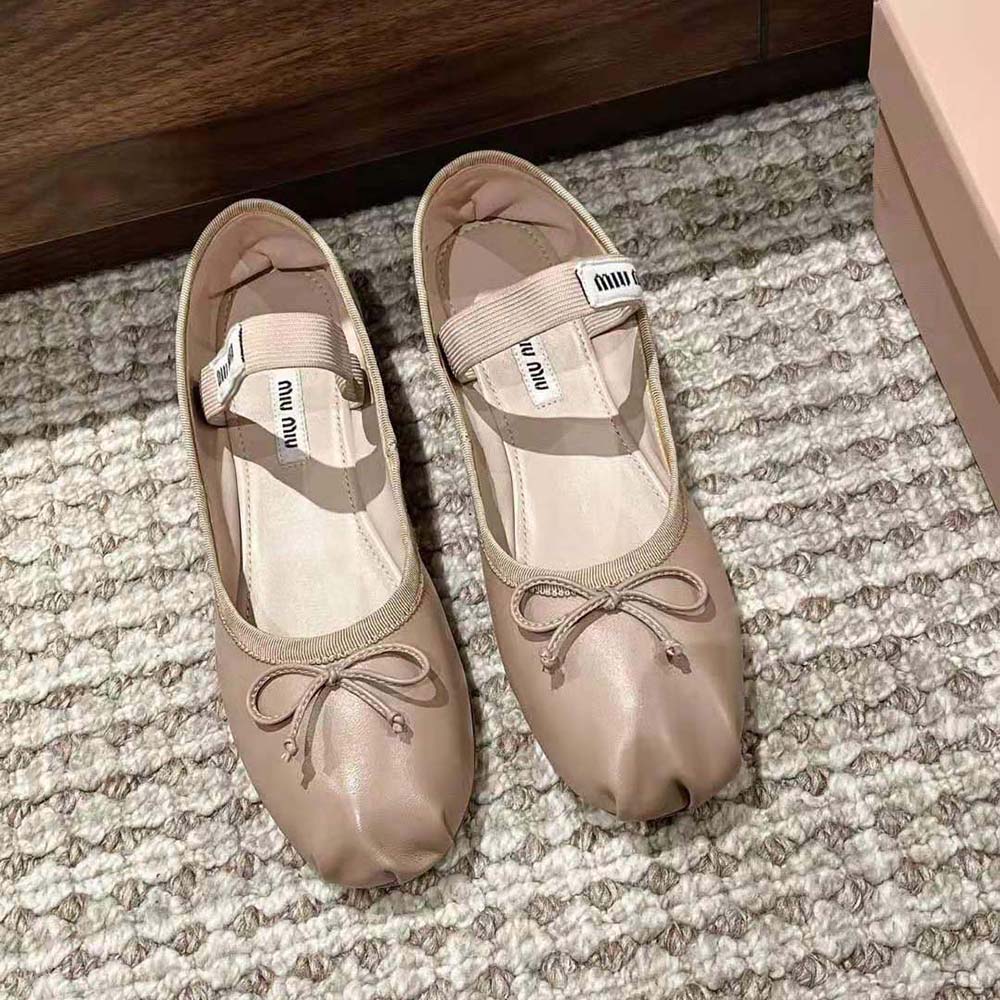 Close-up detail of fabric logo label on Miu Miu beige ballerina