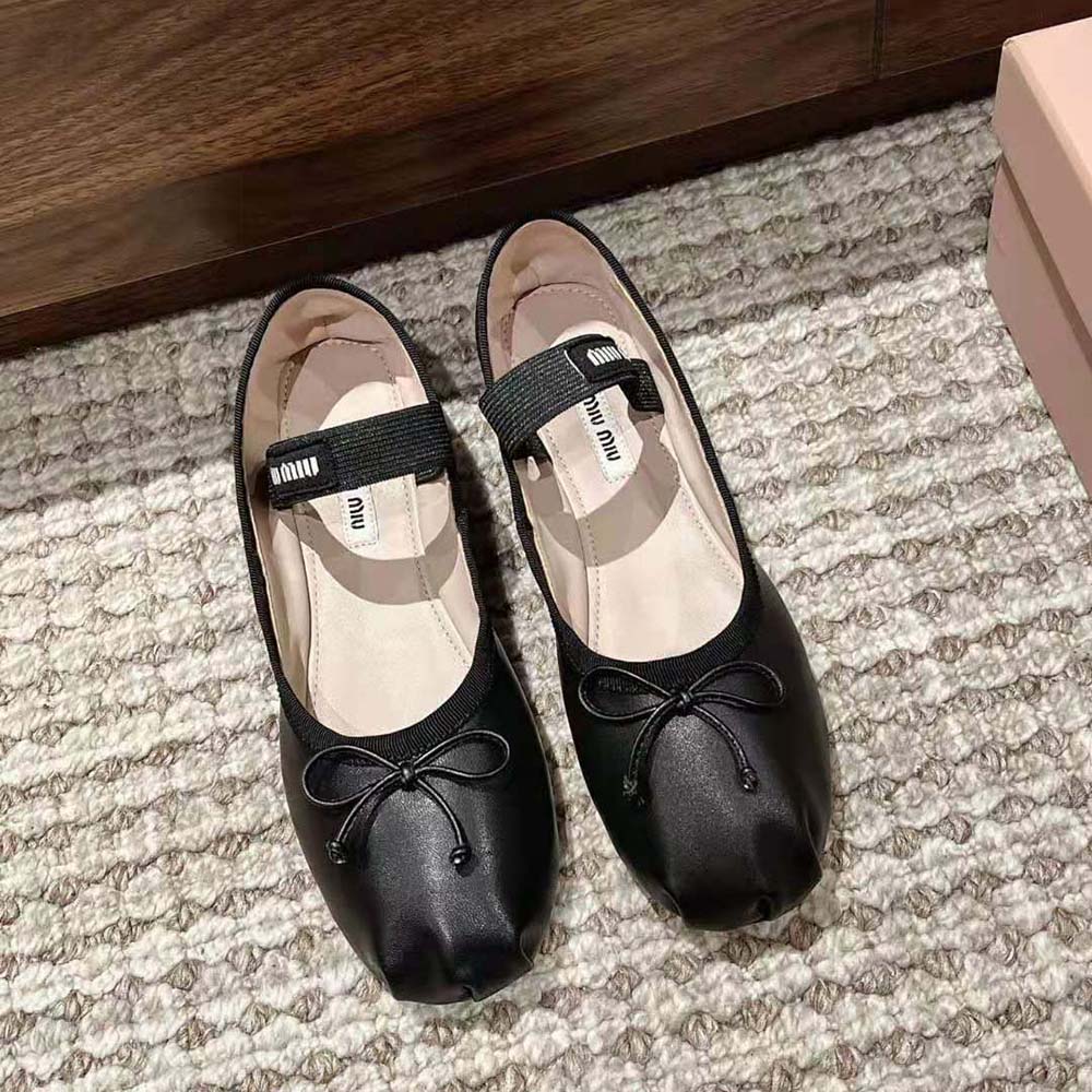 Close-up of fabric logo label on black leather ballerinas by Miu Miu