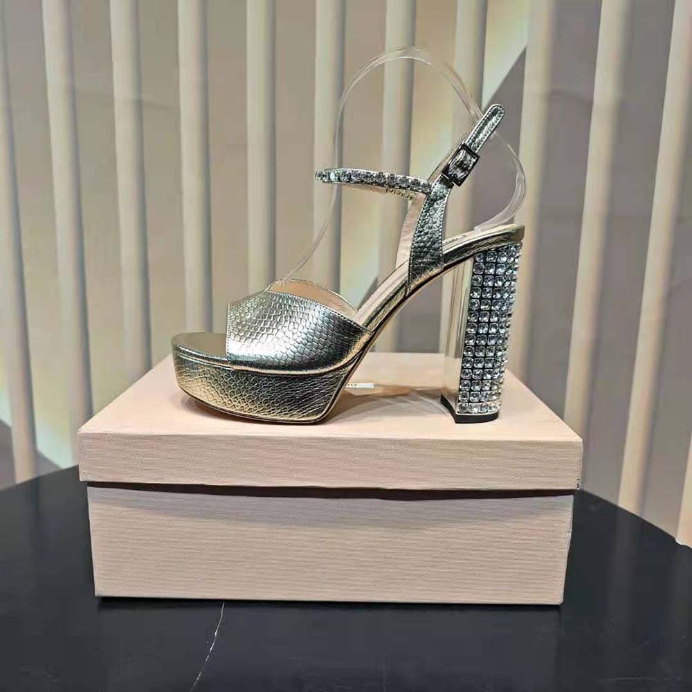 Close-up detail of gold-tone hardware on Miu Miu platform sandals