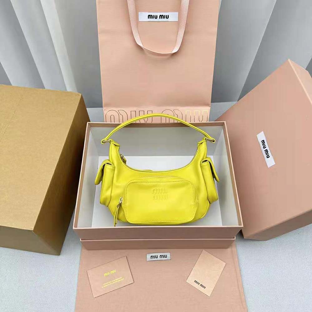 Close-up detail of yellow nappa leather and gold hardware on Miu Miu bag