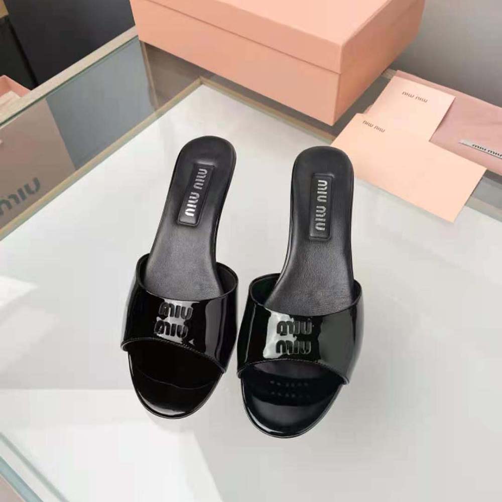 Close-up of black patent leather and silver buckle on Miu Miu sandals