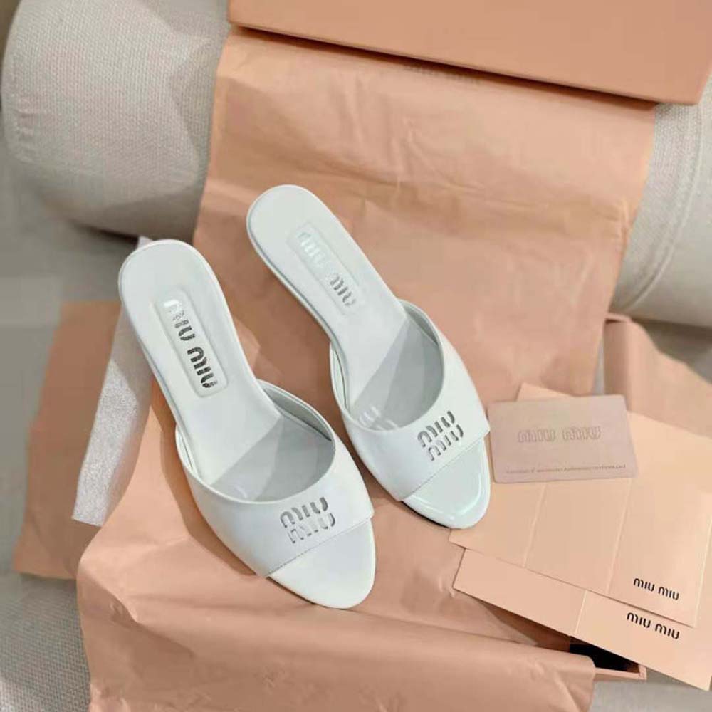 Close-up detail of buckle and signature logo on Miu Miu white sandals