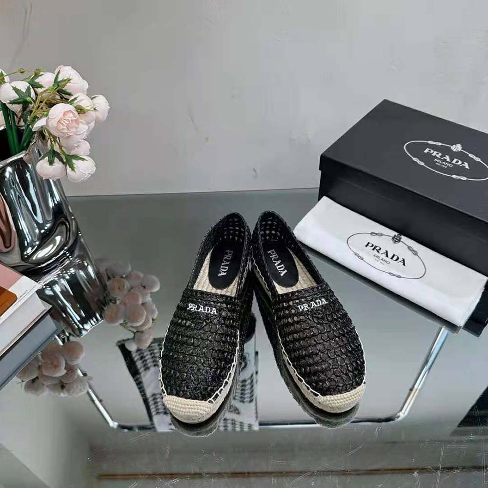 Close-up of embroidered Prada logo on black crochet espadrilles