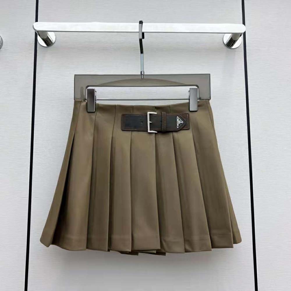 Close-up of enameled metal Triangle logo on Prada miniskirt