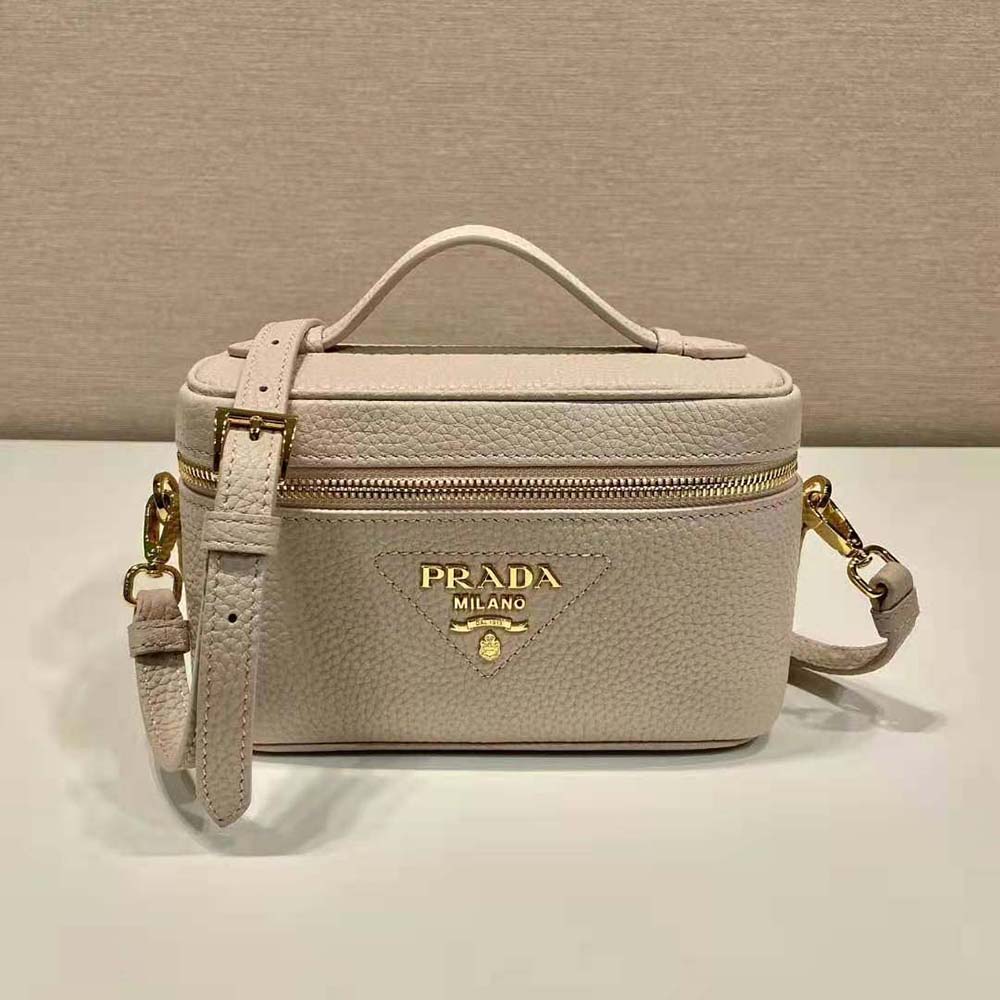 Close-up detail of sandy leather and polished clasp on Prada mini bag