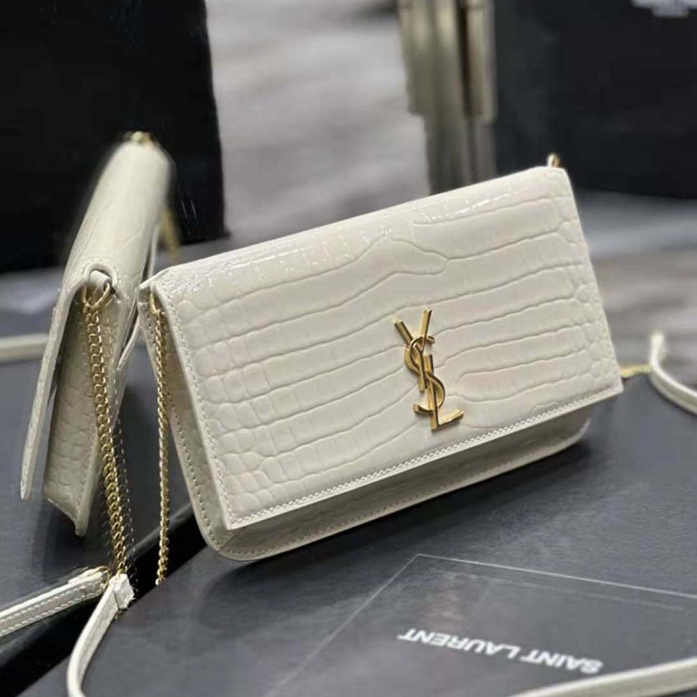 Close-up of gold YSL logo on shiny crocodile-embossed leather phone holder