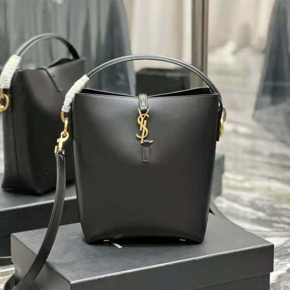Close-up detail of YSL logo hardware on shiny black leather bag