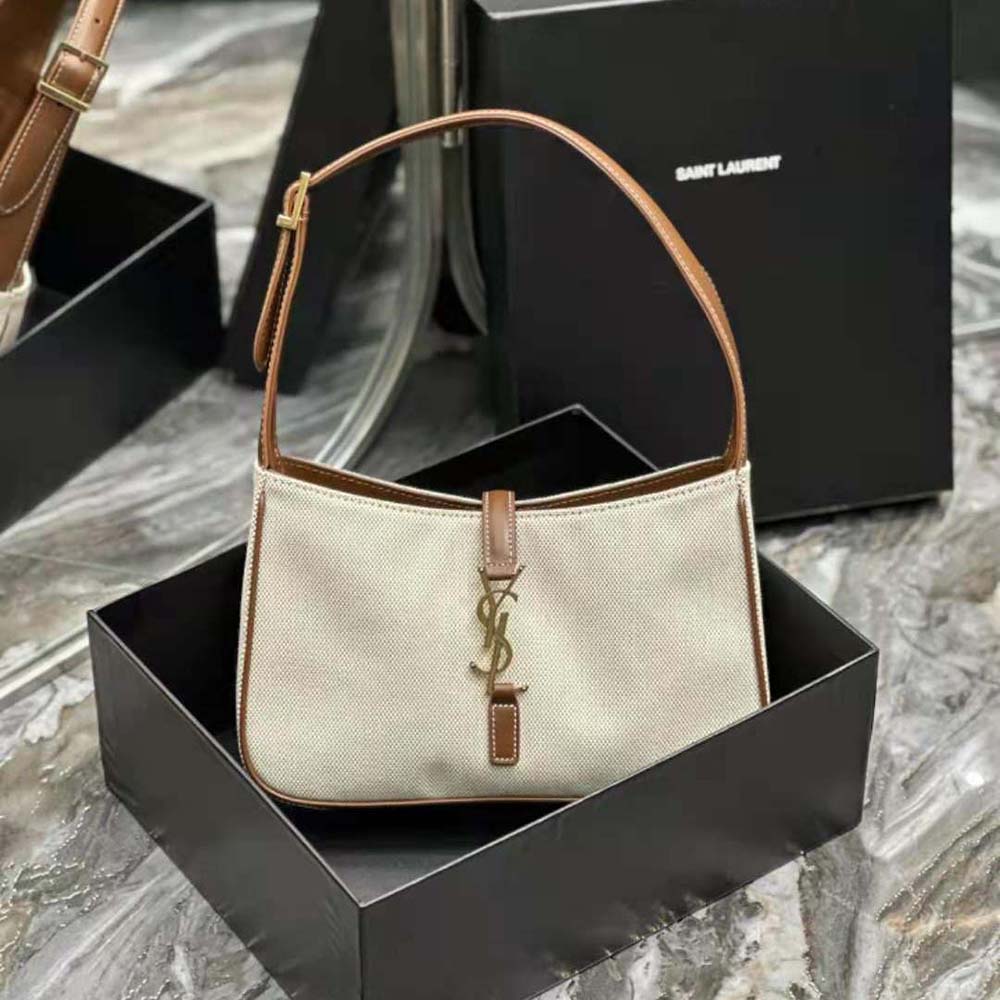 Close-up of gold YSL logo hardware on beige Saint Laurent YSL Women Le 5 à 7 bag