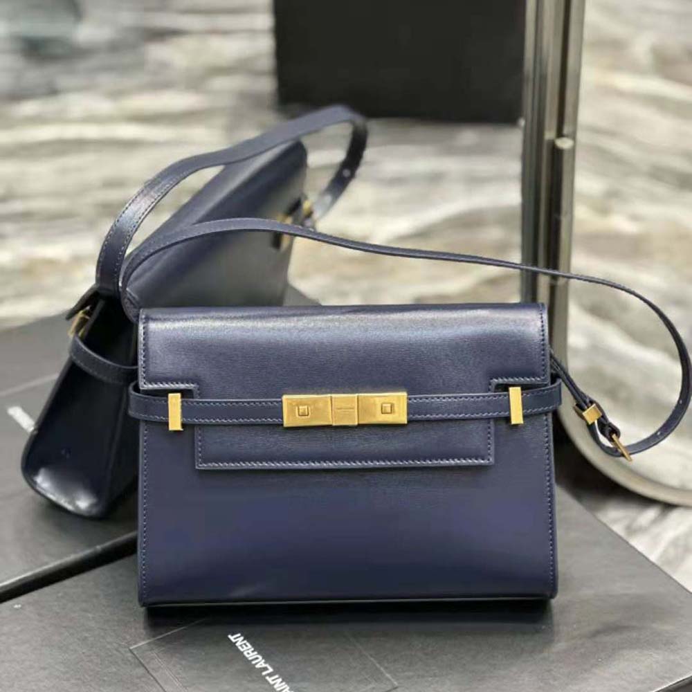 Close-up of gold-tone YSL logo on navy leather shoulder bag
