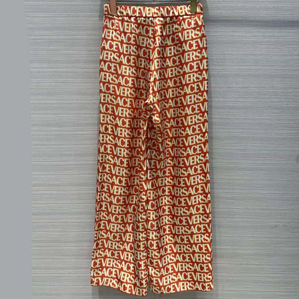 Side angle showing relaxed silhouette of Versace Women Allover Silk Pants