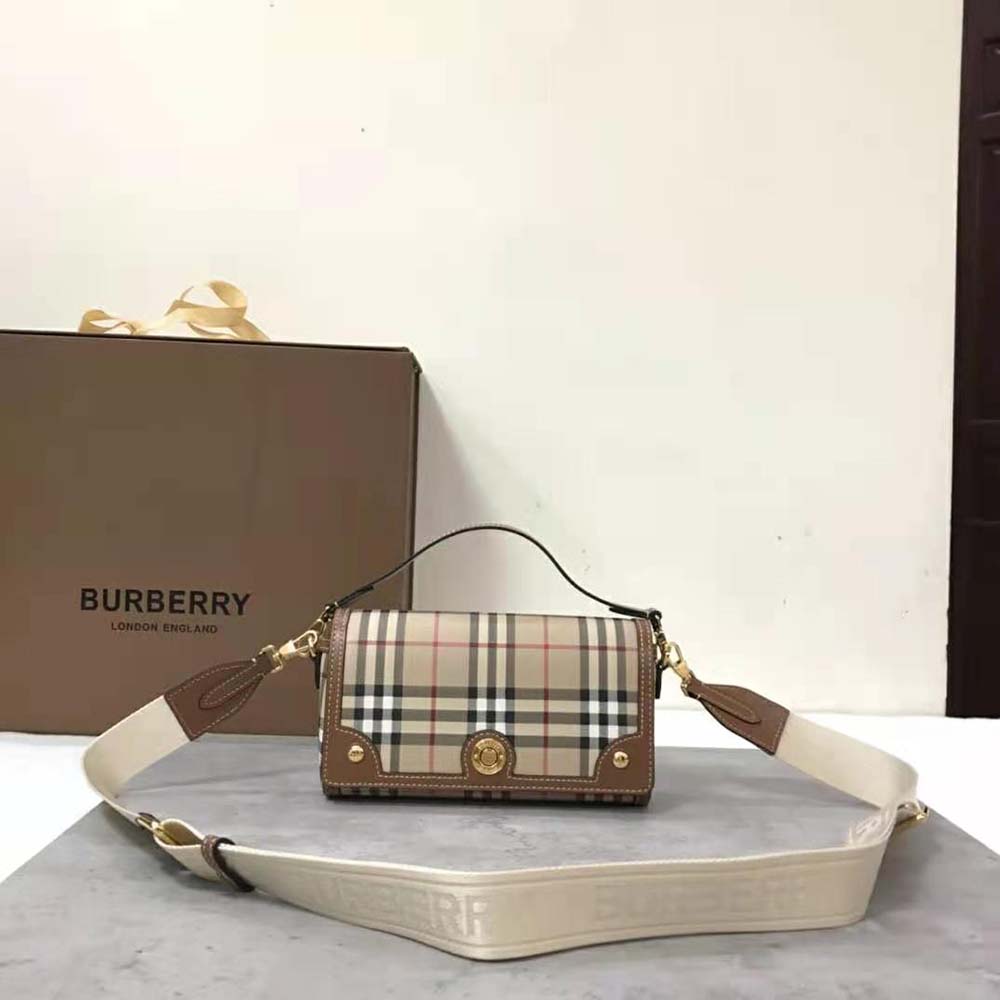 Close-up of gold logo-engraved studs on Burberry Women Top Handle Note Bag
