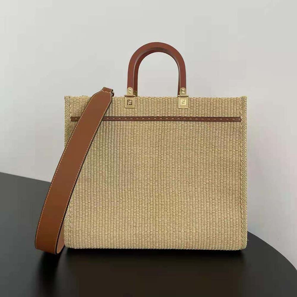 Side angle showing beige straw texture and shoulder strap of Fendi bag