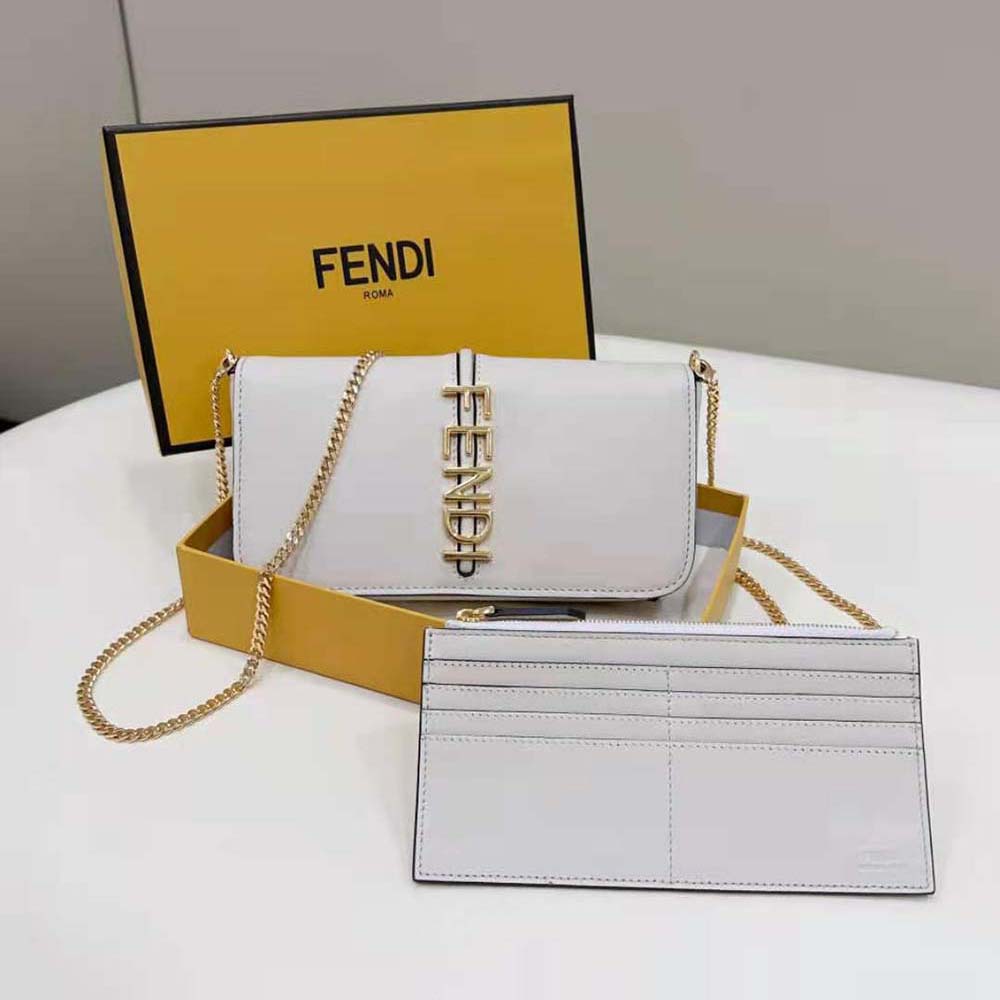 Close-up of gold-tone Fendigraphy logo hardware on white leather pouch
