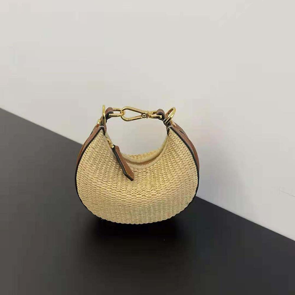 Close-up detail of gold Fendigraphy charm on raffia bag