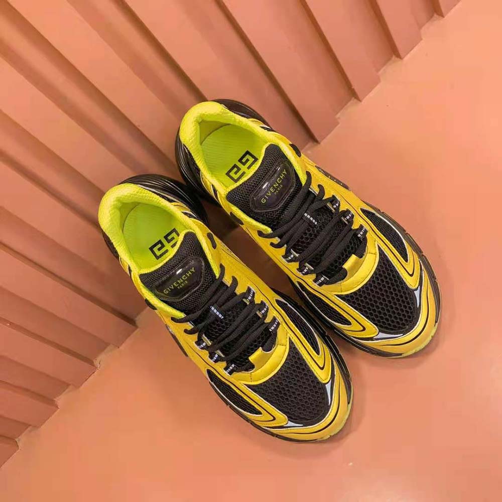 Close-up on Givenchy logo heel tab of mesh-yellow runner sneakers