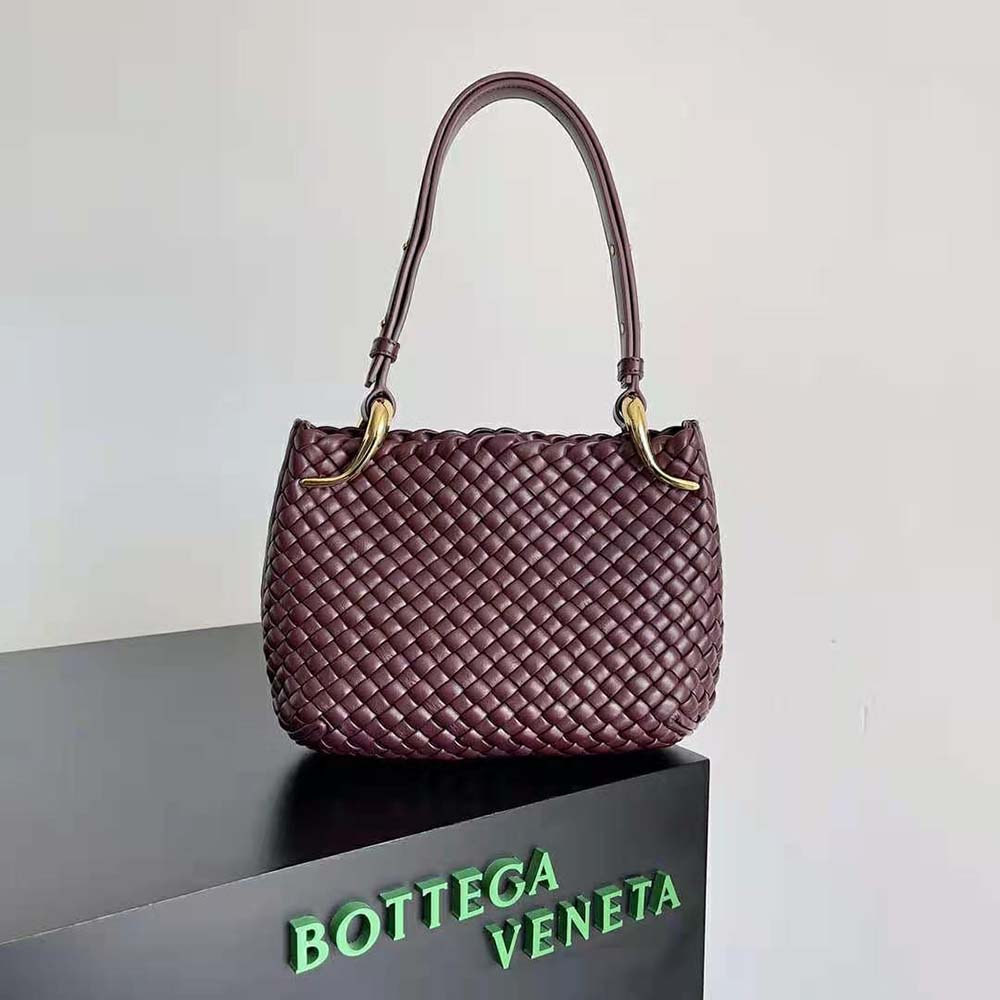 Close-up of maroon intrecciato leather and gold-tone hardware on the bag
