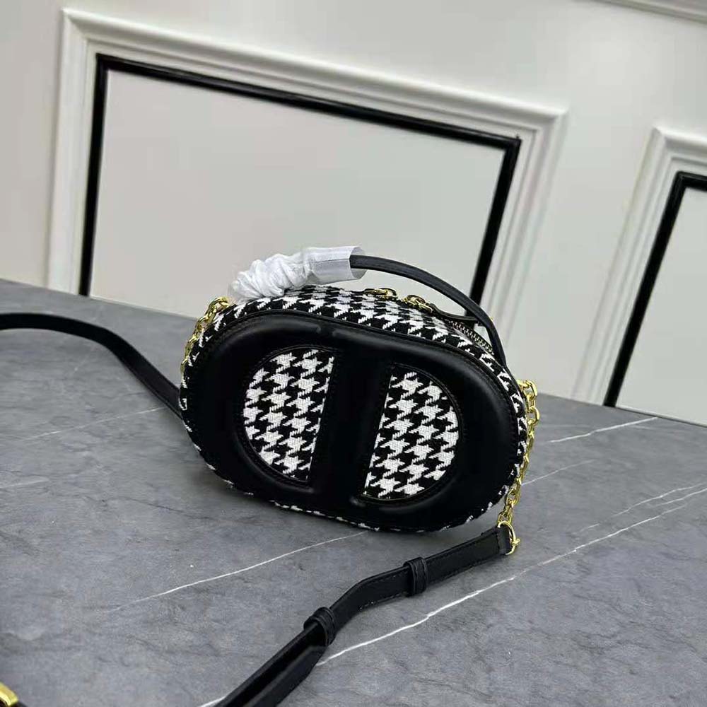 Close-up of CD-embossed signature detail and silver hardware on camera bag
