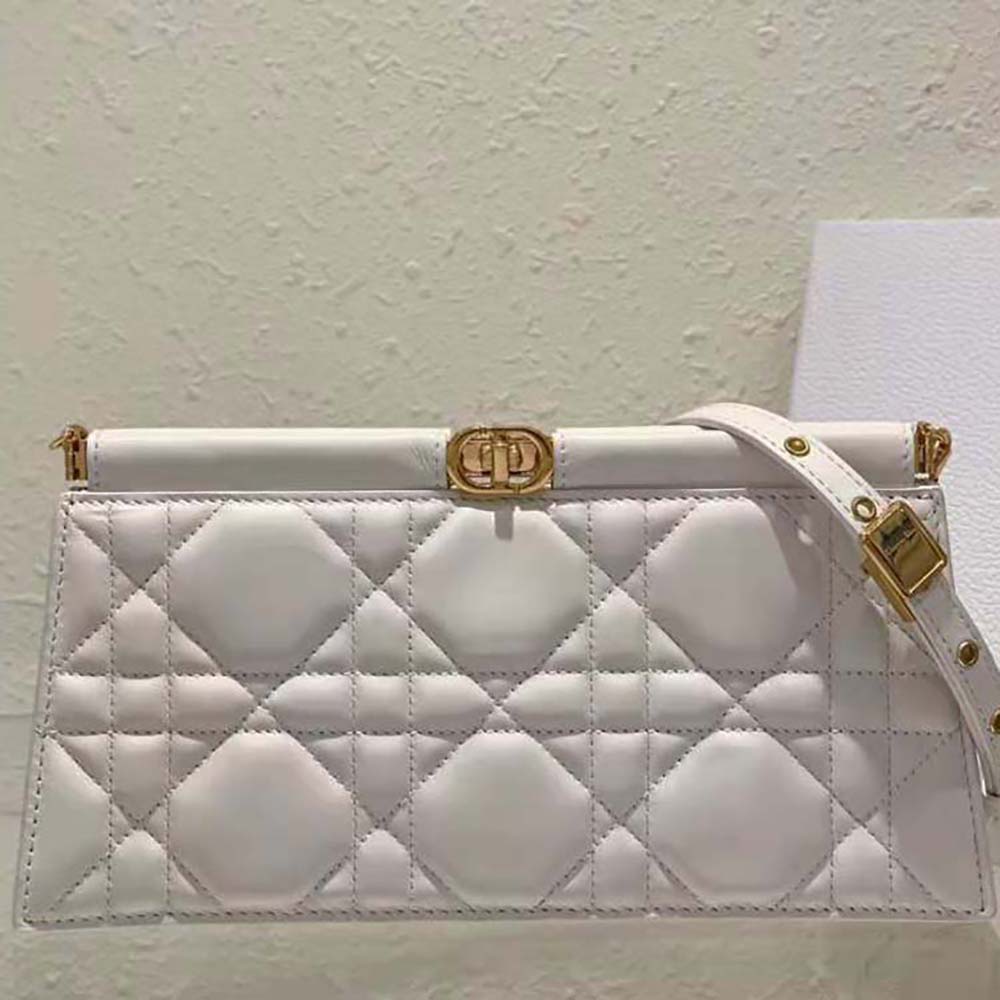 Side angle showing silver-tone chain strap on Dior Caro Colle Noire Clutch