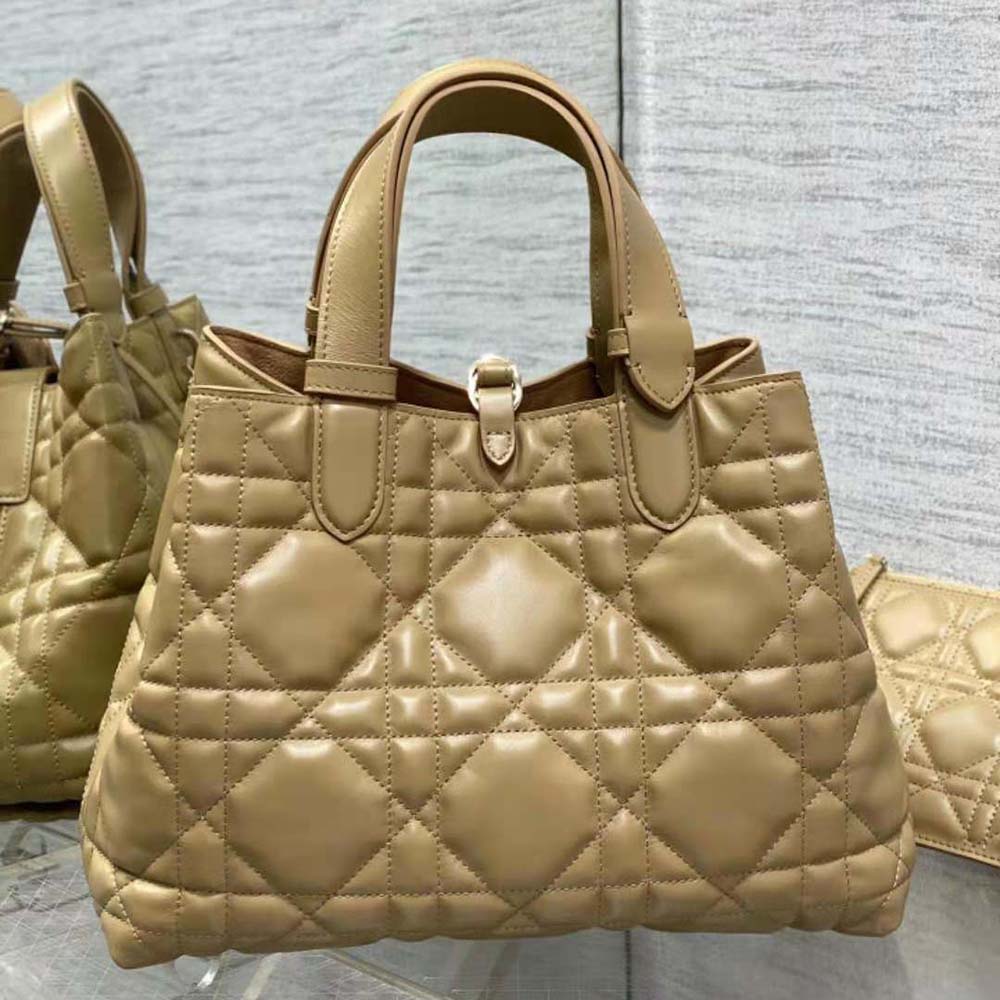 Side angle showing flap closure and adjustable shoulder strap of Dior Toujours bag