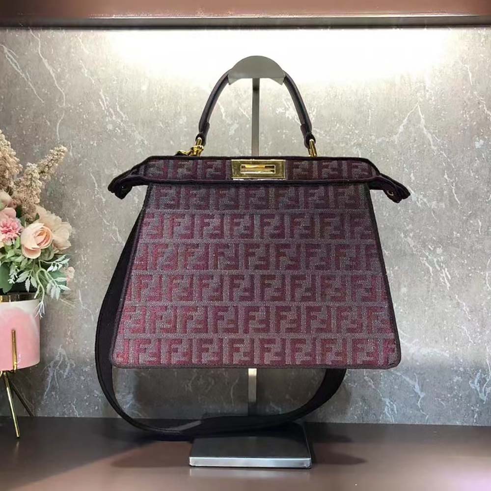 Close-up of maroon tapestry fabric and gold hardware on Fendi Peekaboo ISeeU bag