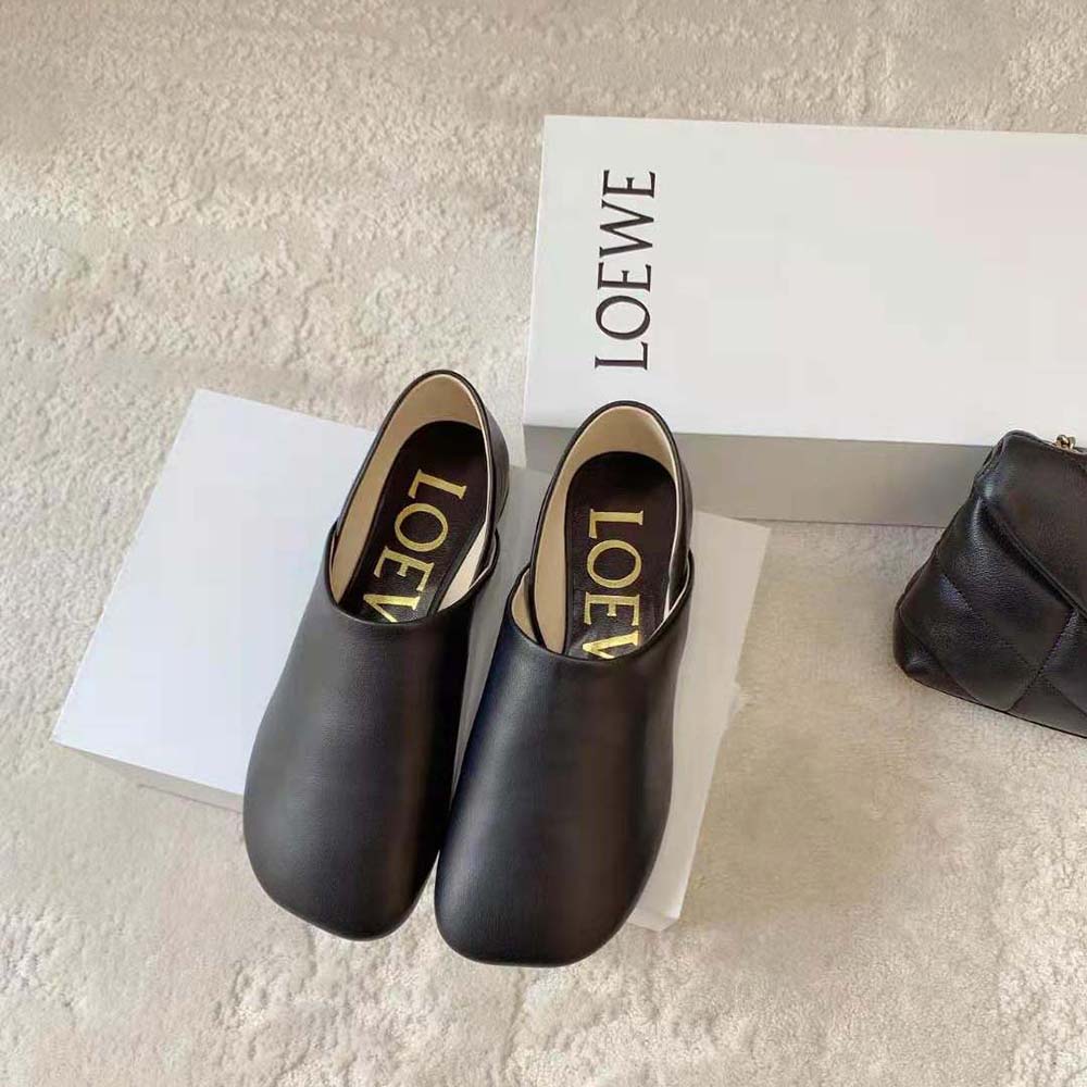 Close-up detail of embossed Loewe logo on black goatskin leather slipper