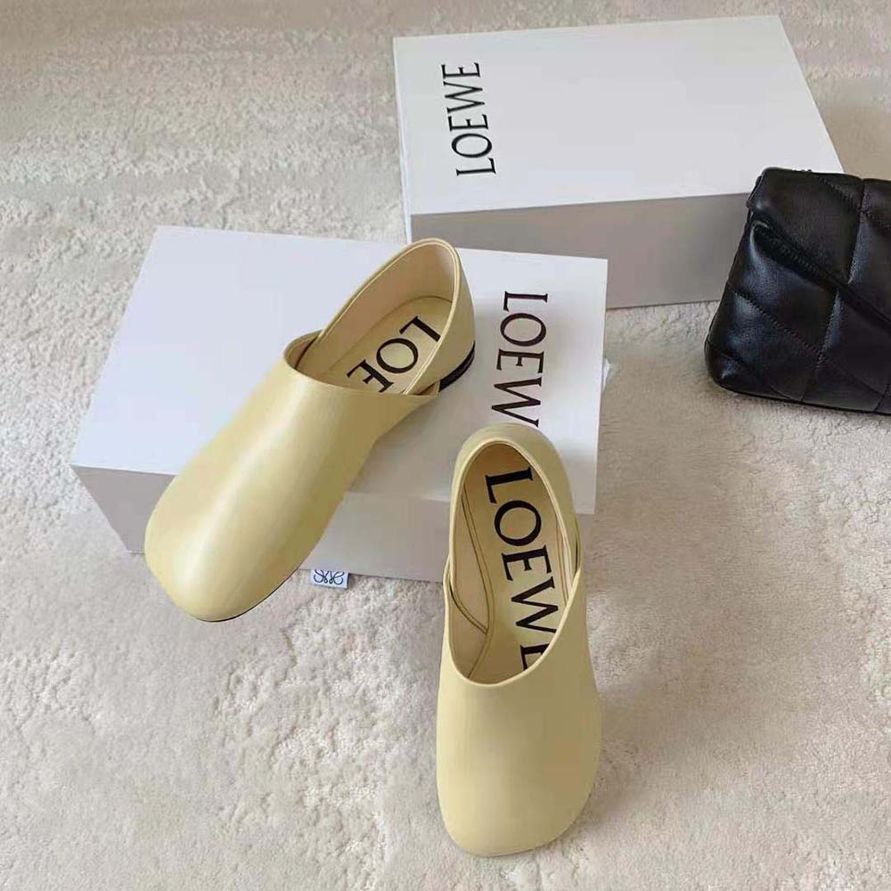 Close-up detail of yellow goatskin leather and Loewe logo embossing on slipper
