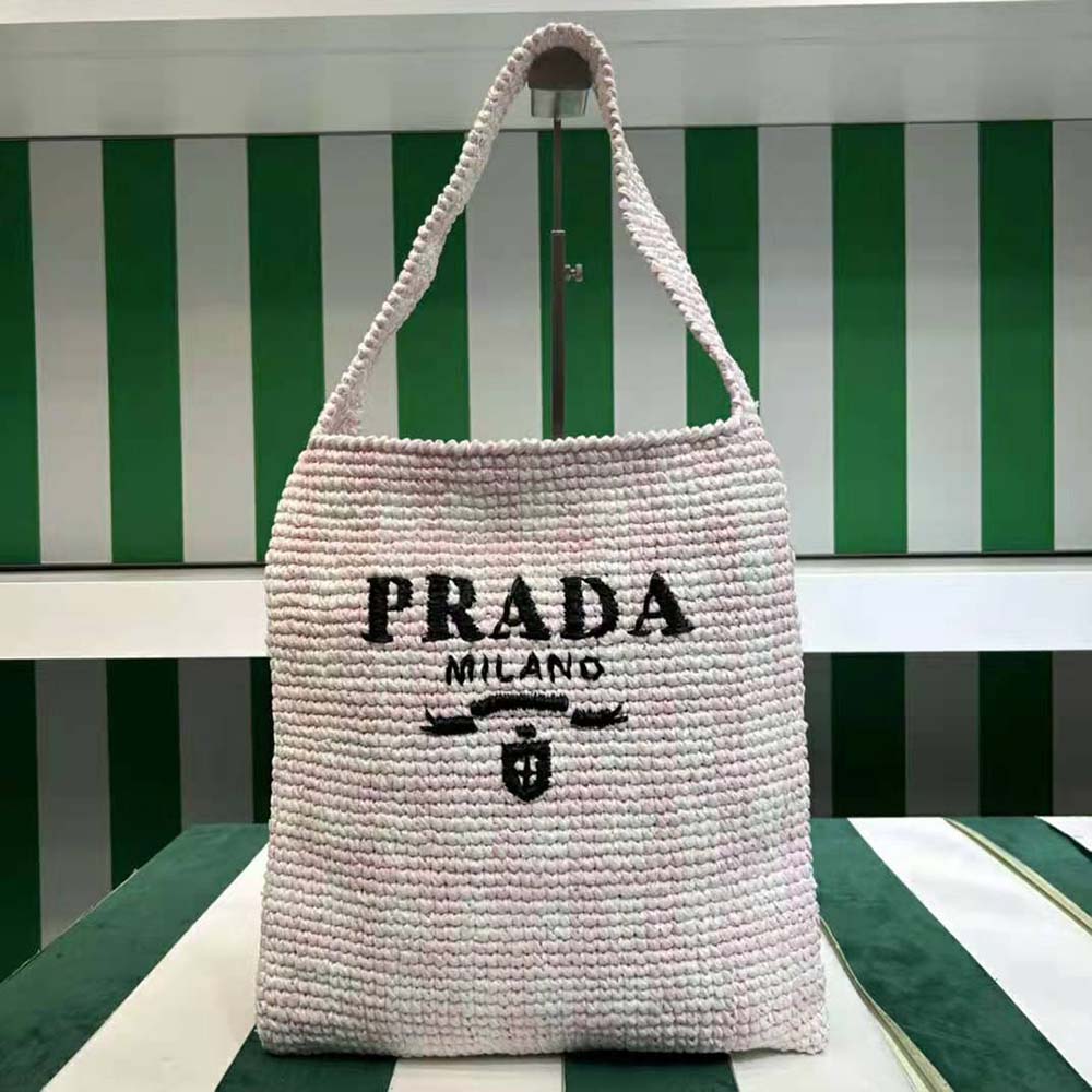 Close-up of embroidered Prada logo on pink crochet tote bag