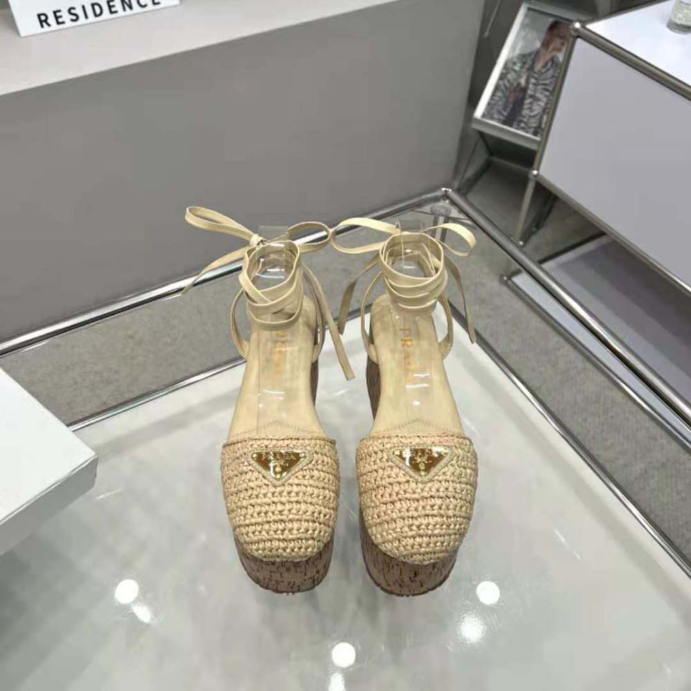 Close-up of enameled metal triangle logo on Prada Women Crochet Wedge Sandals