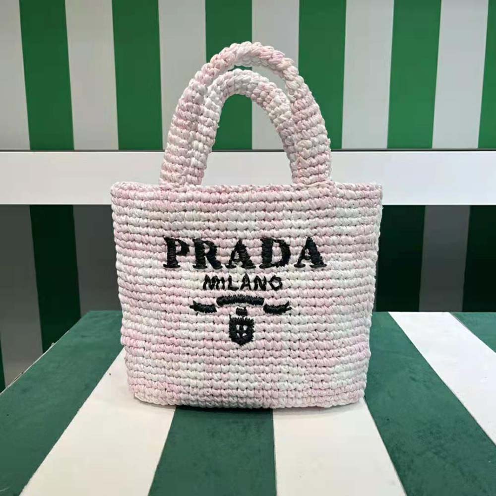 Close-up of embroidered Prada logo on crochet surface in pink tote bag