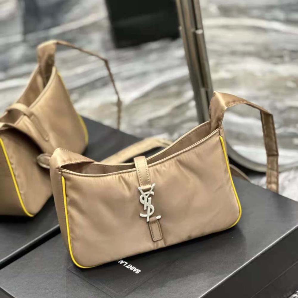 Close-up gold YSL logo hardware on yellow crossbody bag by Saint Laurent