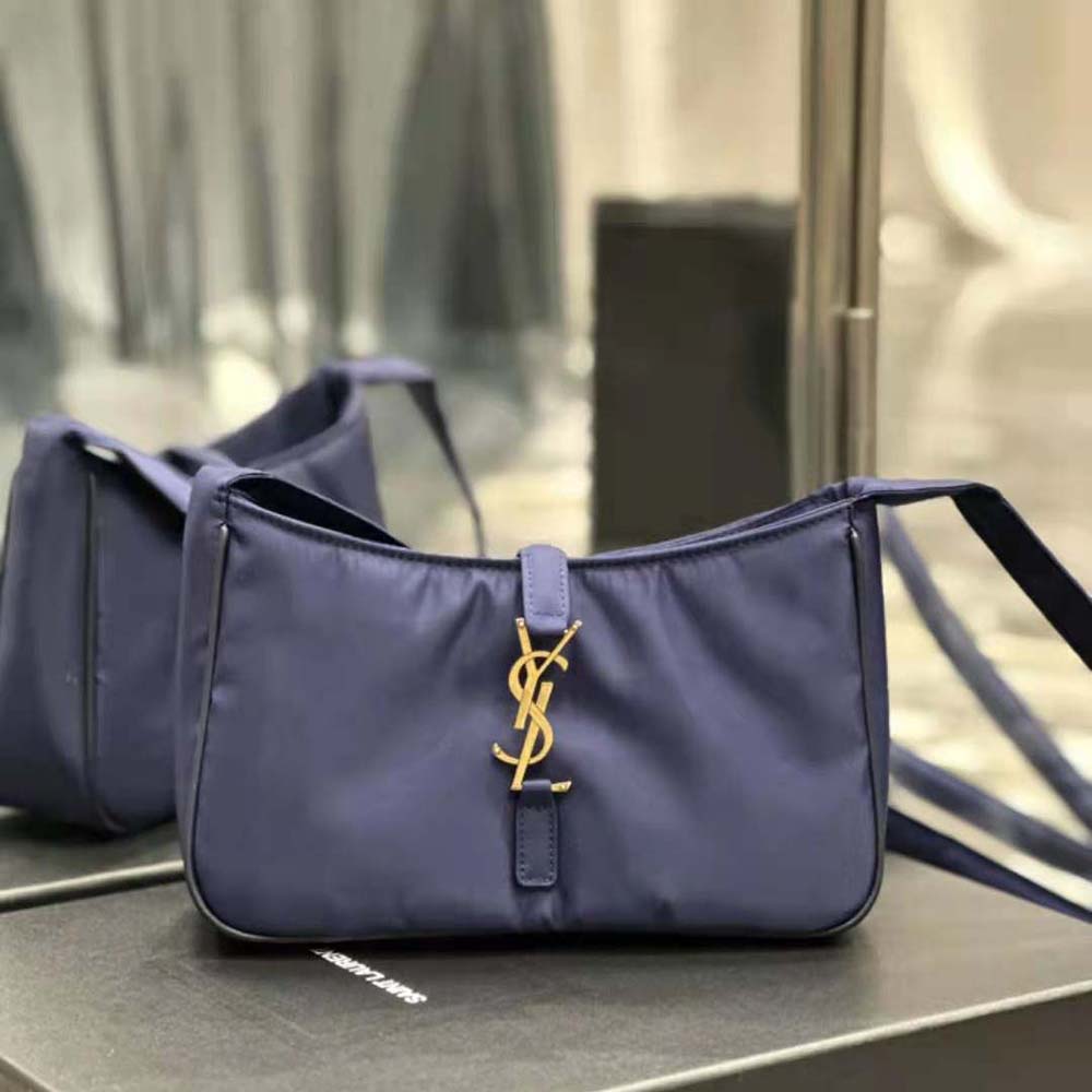 Close-up of silver YSL logo hardware on navy crossbody bag