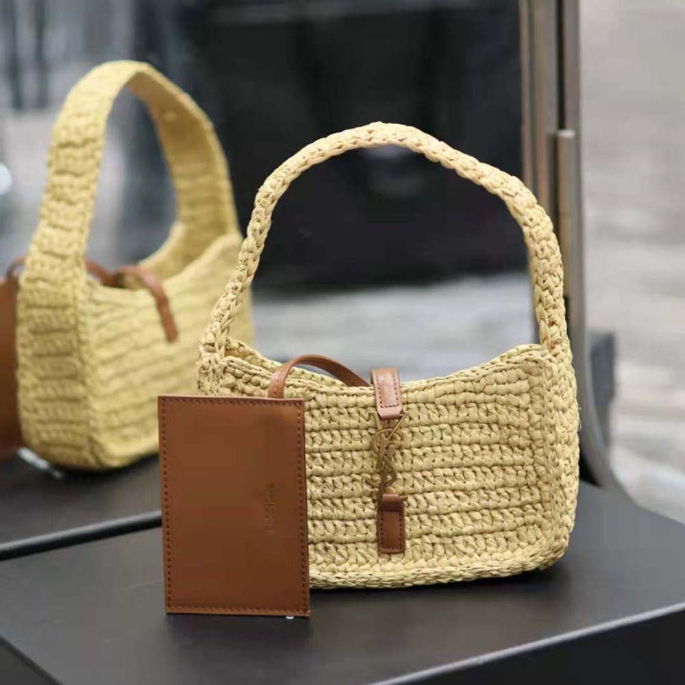 Close-up of gold-tone YSL logo hardware on raffia mini bag