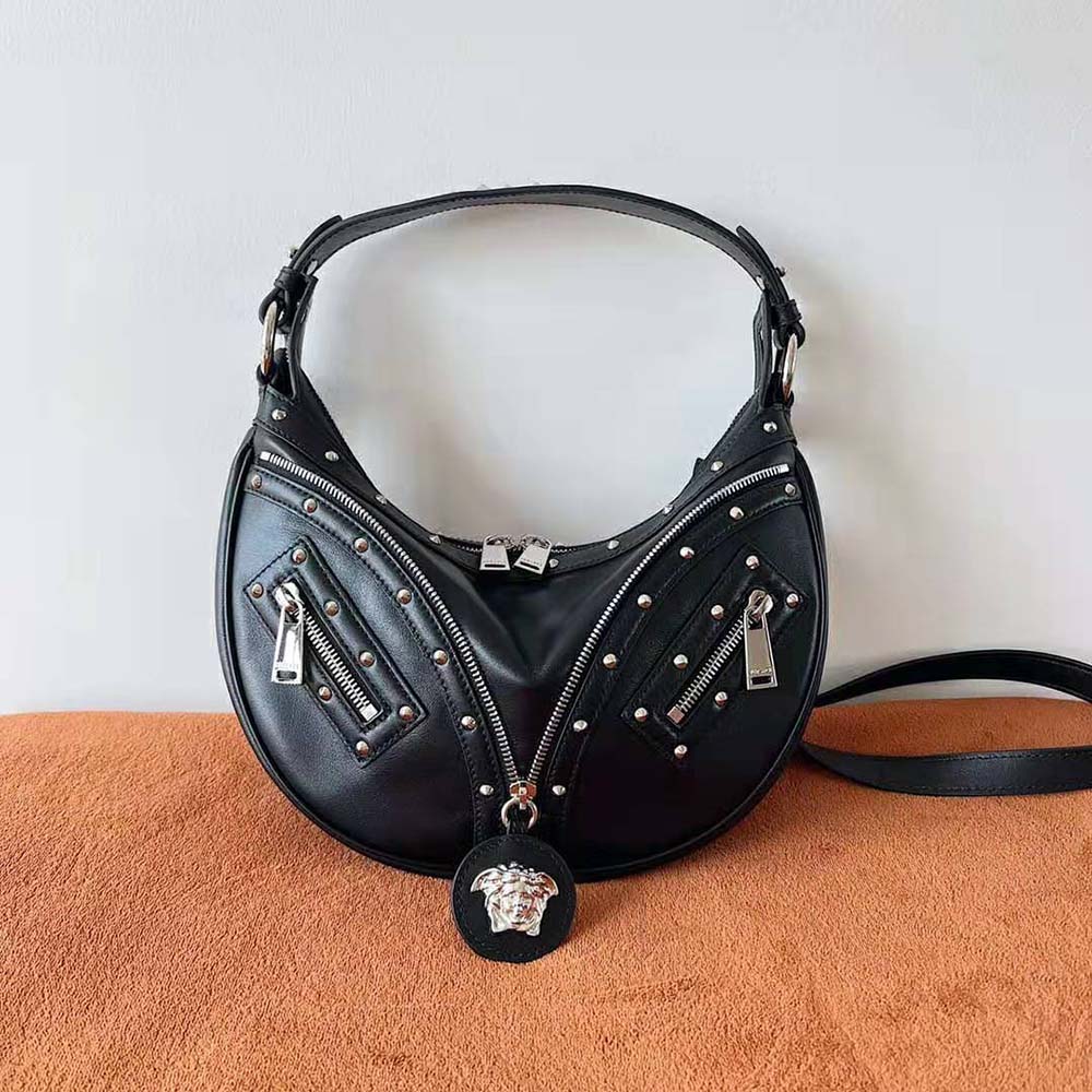 Close-up of gold-tone hardware on Versace Women Repeat Small Hobo Bag-Black